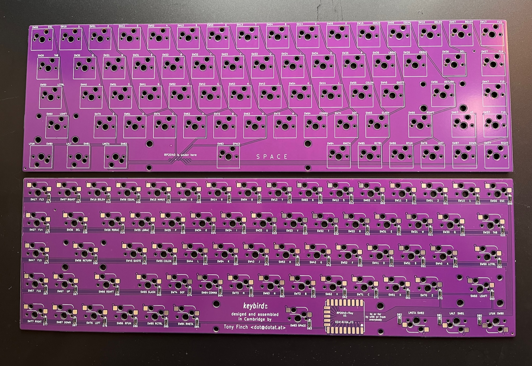two purple keyboard PCBs, one showing the top and the other the bottom